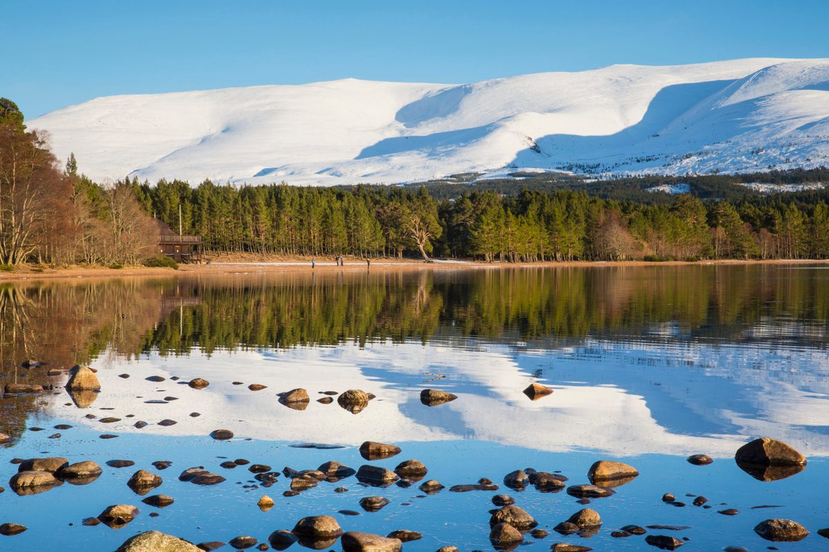 Loch Morlich with snowy mountains in background